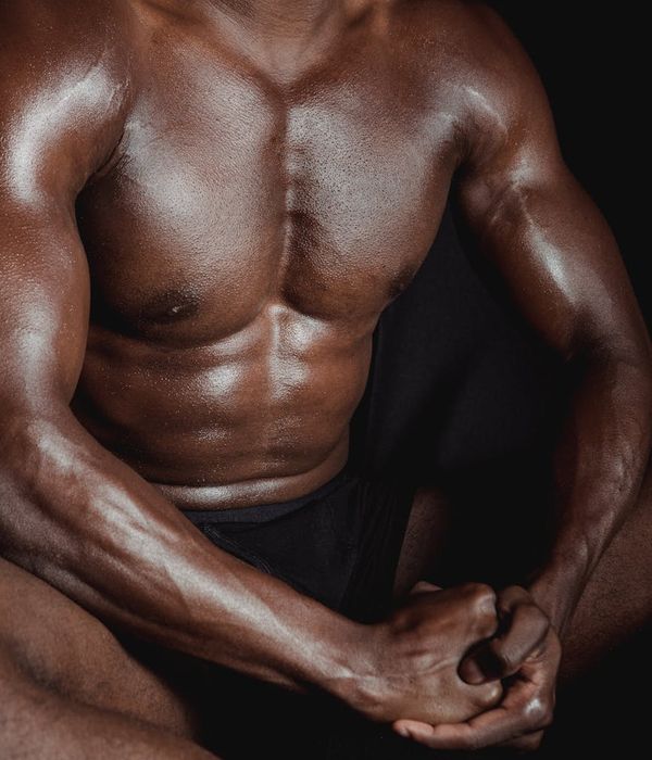 Man in a controlled athletic stance showing muscle definition.